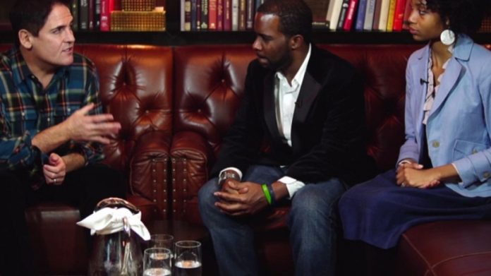 Mark Cuban sitting with a man and a woman on a leather couch